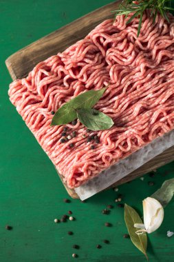 Çiğ kıyma, kıyma dilimlenmiş et. Yeşil arka plan. Üst görünüm