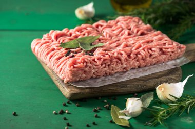 Çiğ kıyma, kıyma dilimlenmiş et. Yeşil arka plan. Üst görünüm
