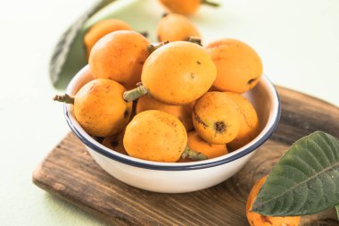 Olgun medlar meyve, Eriobotrya japonica ve ahşap masada yeşil Medlar yapraklar. Üst görünüm