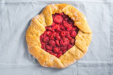 Evde çilekli galetta, mavi arka planda üst manzara.