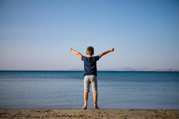 少年は夏休みにビーチで遊ぶ 海の水の中を走る美しい海と砂と青の自然の中の子供たち — ストック写真