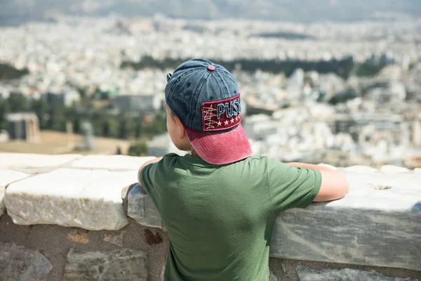 ギリシャのアテネ 幼児の少年はLycabettus Hillから古代の景色を見ることができます 都市の街並み 青い海と空の背景 — ストック写真