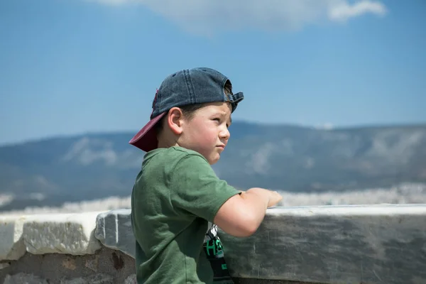 ギリシャのアテネ 幼児の少年はLycabettus Hillから古代の景色を見ることができます 都市の街並み 青い海と空の背景 — ストック写真
