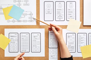 Web UX designer working on mobile responsive website. Flat lay image of numerous app wireframe sketches and user flow over product designer desk.  clipart