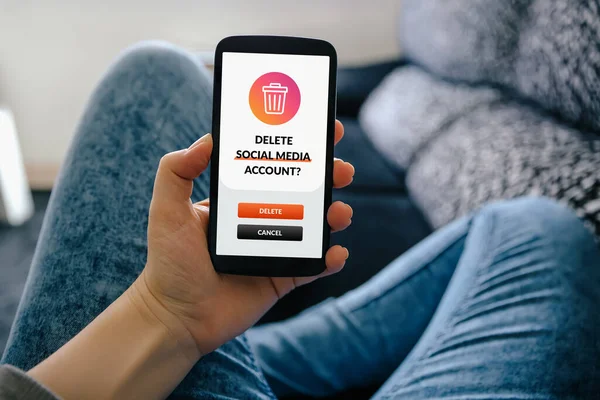 Akıllı telefonlu genç bir kız sosyal medya hesabını siliyor.
