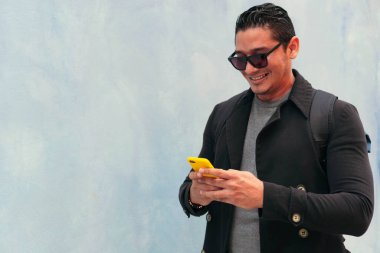 Sokakta cep telefonu kullanan Latin bir adam. İletişim konsepti