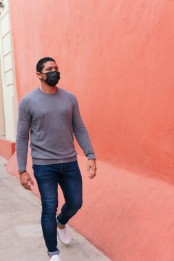 Koruyucu maskeli bir adam sokakta yürüyor. Yaşam tarzı kavramı