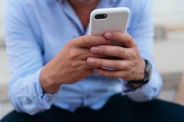 Tanımlanamayan adam cep telefonunu kontrol ediyor
