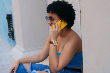 Kadın açık havada telefonda konuşuyor.