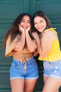 İki gülümseyen Latin 'in portresi. Dışarıda poz veren dost canlısı ve kaygısız kadınlar..