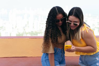 Genç arkadaşlar akıllı telefonlarını açık havada kullanıyorlar.