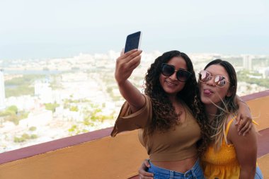 Genç arkadaşlar dışarıda selfie çekiyorlar.