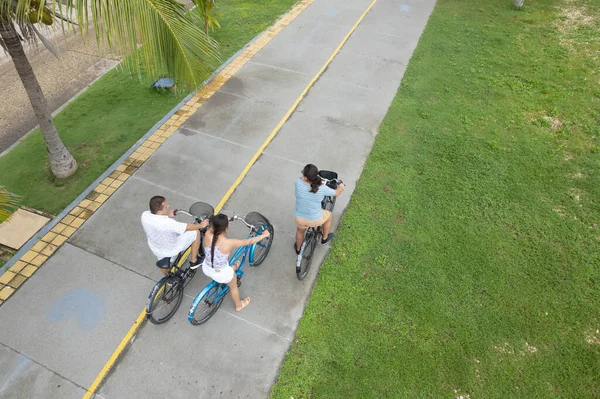 Aerial view of a family riding bicycles in the park.