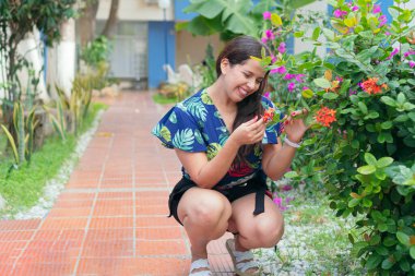 Bahçesindeki bitkilerle ilgilenen genç bir kadın. Şehir Ormanı Konsepti