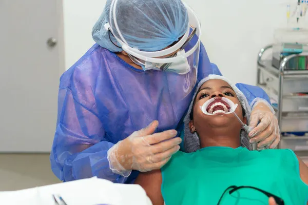 在牙科诊所治疗非洲病人的女牙医 — 图库照片