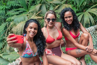 Mutlu arkadaşlar ormanda dururken selfie çekiyorlar. Tatil ve Turizm Konsepti