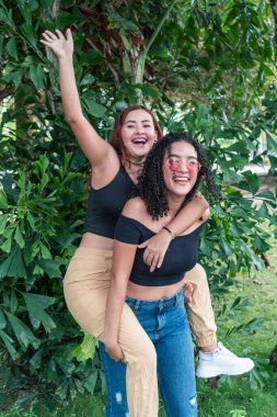 İki arkadaş parktaki bitkilerin yanında eğleniyor..