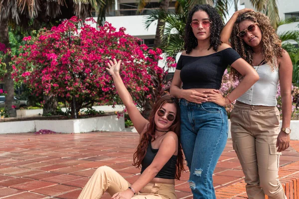 Güneş gözlüklü üç güzel kadının portresi.