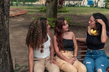 Parkta bir bankta oturan üç arkadaş