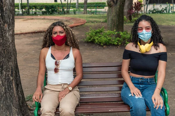 Dos Amigos Con Máscara Protectora Sentados Banco Del Parque —  Fotos de Stock
