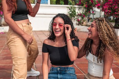 Üç arkadaş parkta sosyalleşiyor.