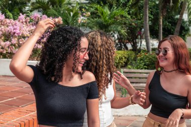 Üç Latin arkadaş dışarıda eğleniyor.