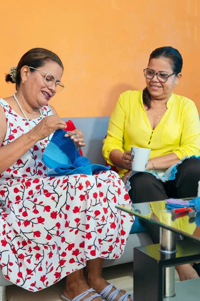 Olgun Latin kadınlar evde örgü örüyor.