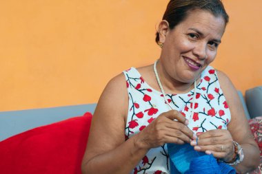 Koltukta oturan ve örgü ören Olgun Kadın Portresi