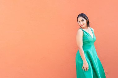 Kırmızı duvarın önünde yürüyen Latin kadın