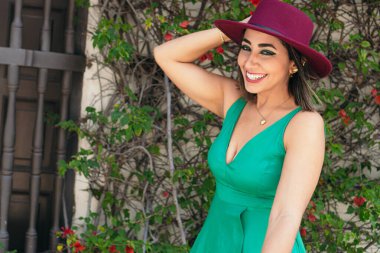 Cheerful woman walking in the park with a hat