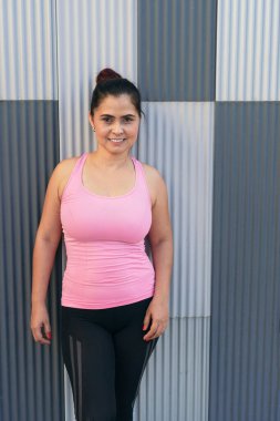 Portrait of happy female in sports clothing standing at park