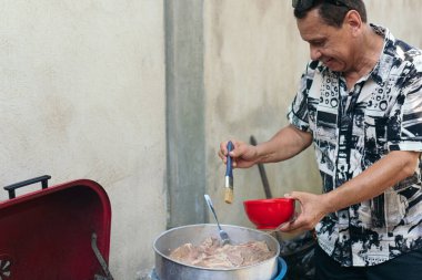 Oder Man dışarıda ızgarada yemek pişiriyor.