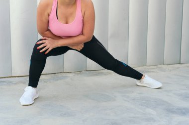 Spor yaparken bacaklarını esneten atletik kadın.