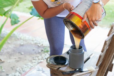 Tanınmayan kadın evde çalışmadan önce boya hazırlıyor.
