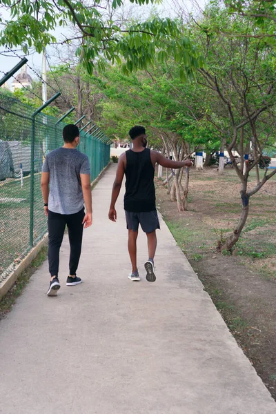 Spor Giyimli Iki Arkadaş Parkta Yürüyor — Stok fotoğraf