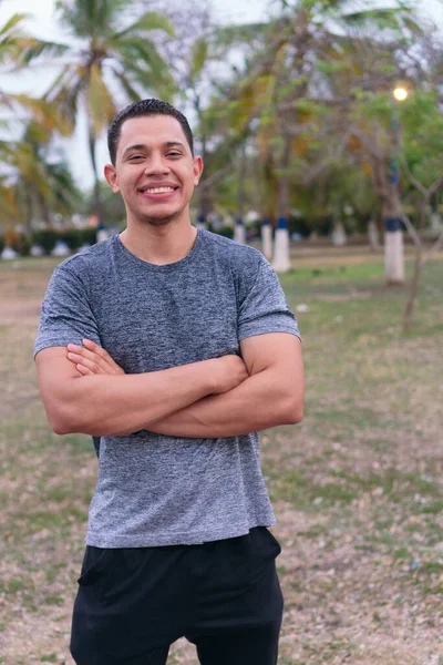 Spor Giyimli Bir Adam Parkta Duruyor Kollarını Kavuşturup Gülümsüyor — Stok fotoğraf