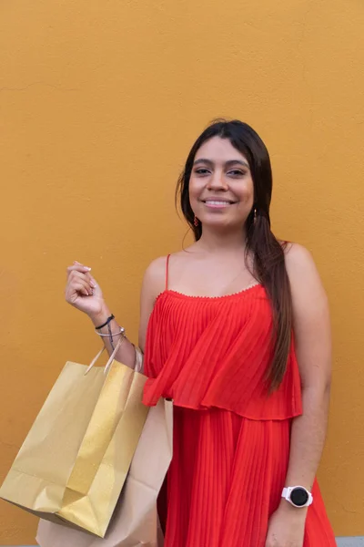 Mujer Vestido Rojo Sosteniendo Bolsas Compras Posando Pared Amarilla —  Fotos de Stock