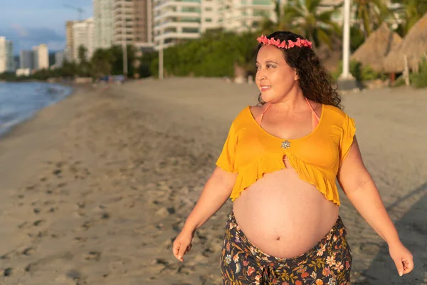 赤ちゃんを期待しているヒスパニック系の女性 彼女の顔に深刻な表情でリラックス ビーチに立つシンプルで自然な — ストック写真