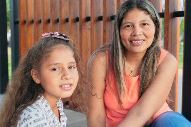 Bir anne ve kızı mutlu bir şekilde parkta oynuyorlar.