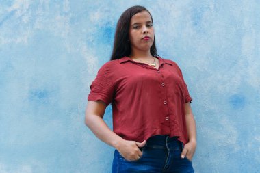 Elleri cebinde Latin bir kadın.