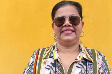 Sarı duvarın önünde gülen kadın