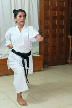 Geleneksel kimono giymiş İspanyol kadın evde karate yapıyor.