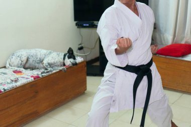Geleneksel kimono giymiş bir kadın evde karate yapıyor.