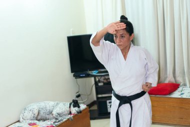 Olgun kadın karate sanatını icra ediyor.