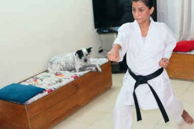 Karate eğitimi sırasında yumruk atan bir kız.