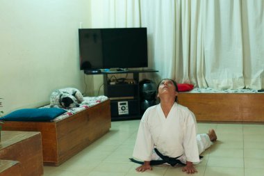 Evinde siyah kuşaklı beyaz bir kimono giyen Latin kadın..