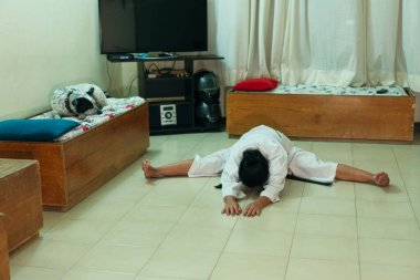 İspanyol kadın evde karate yapıyor. Bacak esnetiyorum. Karate siyah kuşağı.