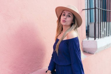 Şehir caddesinde duran gülümseyen bir kadının portresi.