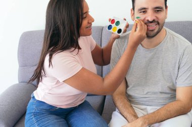 Brezilya bayrağını arkadaşının yüzüne boyayan kadın.