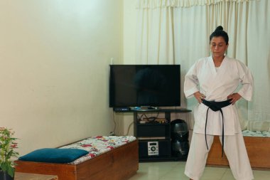 Siyah kuşaklı İspanyol karateci kız evde pratik yapıyor.